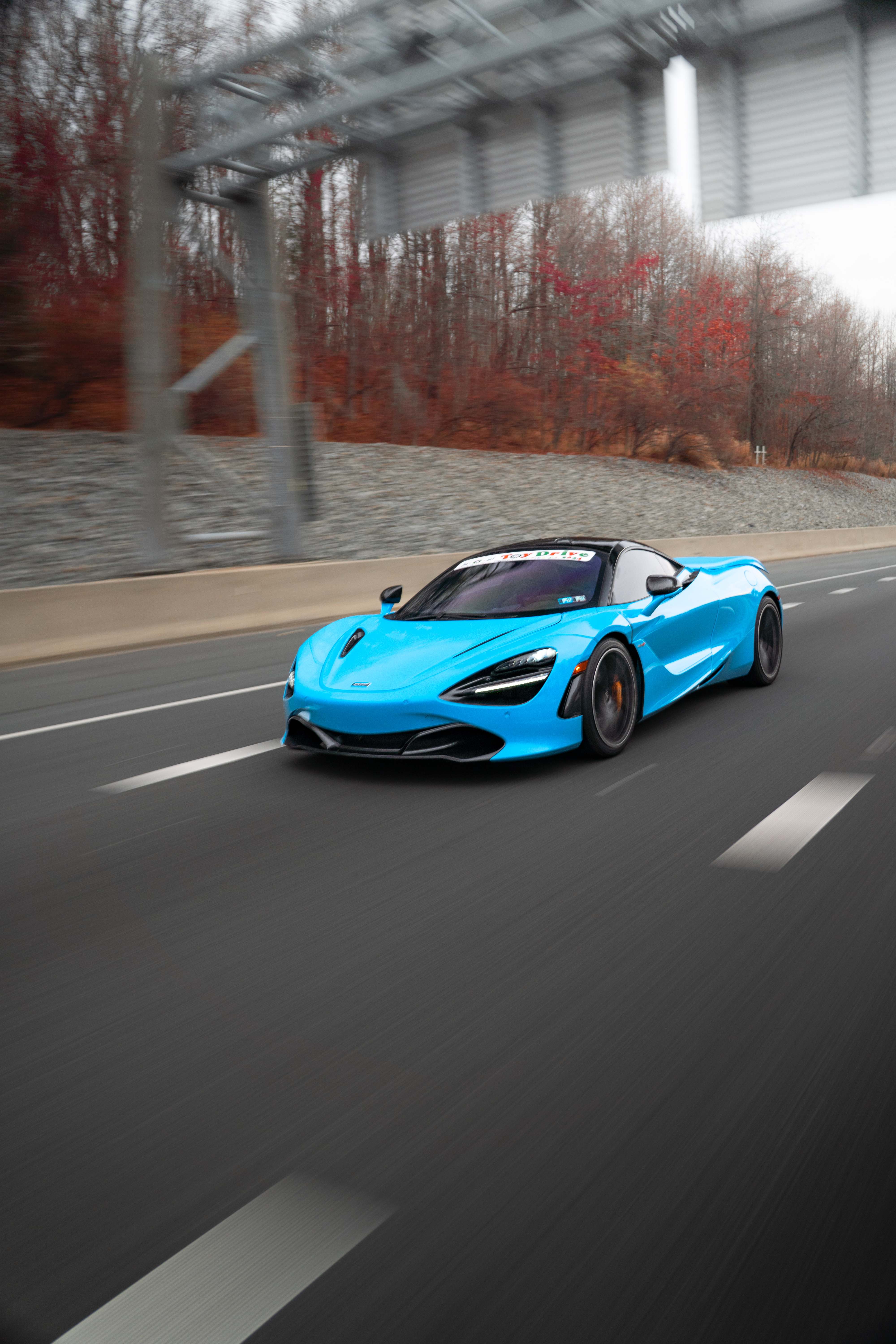 McLaren in motion with blurred background for dynamic effect, showcasing sleek design and vibrant color